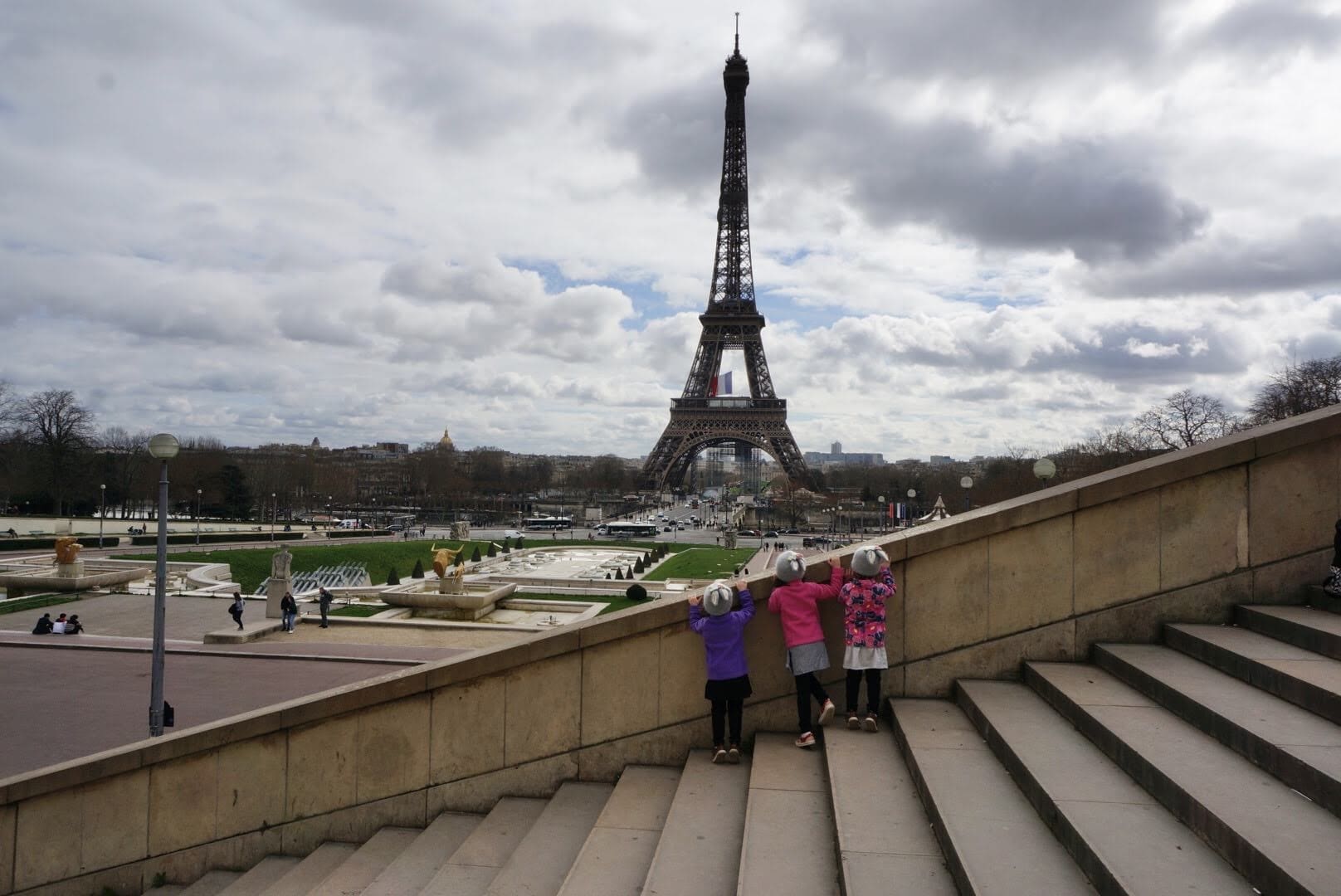 3 little girls standing in front of the Eiffel Tower